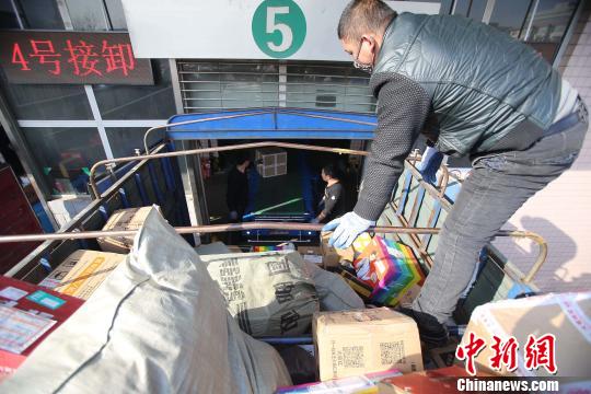 資料圖：工作人員正在給快遞包裹裝車。張?jiān)啤z